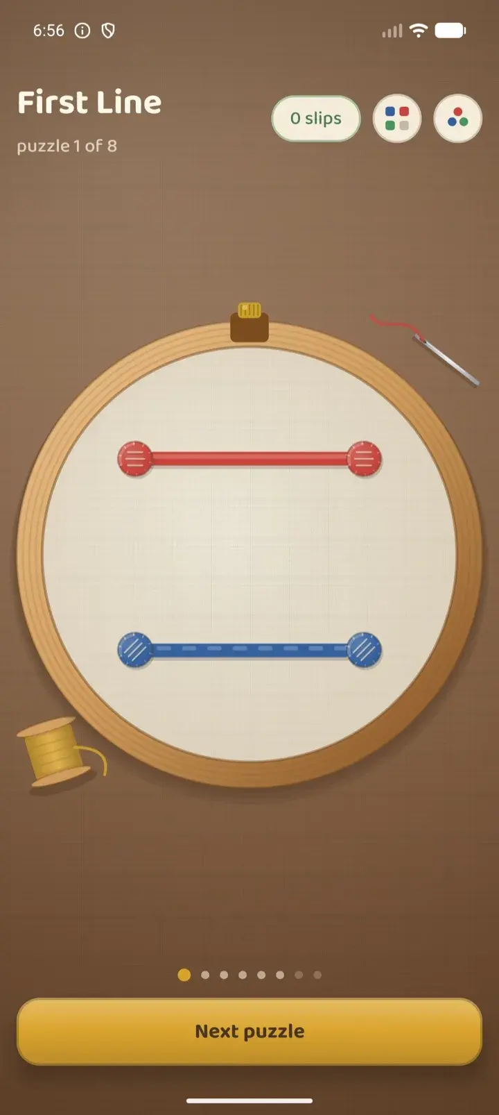 The first puzzle solved, with a red and a blue thread stitched across the hoop.